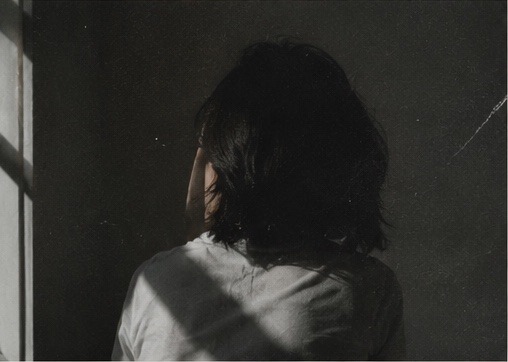 A woman in soft silhouette, contemplative